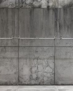 a man riding a skateboard on top of a cement floor next to a wall