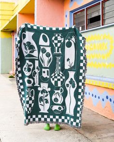 a green and white blanket sitting on the side of a building