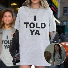 a woman wearing a t - shirt with the words i told ya printed on it