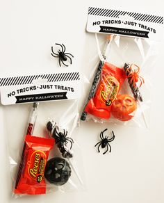 two halloween candy bags with candies in them on a white surface, one is wrapped in cellophane and the other has spider webs