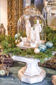 a snow globe with christmas decorations and ornaments around it on a table in front of a mirror