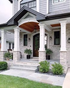 the front porch of a house with white columns and pillars