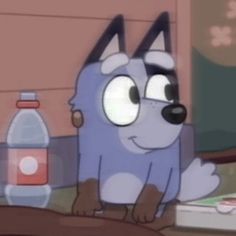 a cartoon dog sitting on top of a wooden table next to a bottle of water