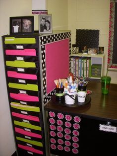 a black and white desk with lots of pink and green items on it