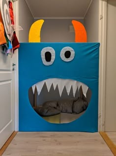 a blue monster bed in the shape of a dog house with its mouth open and eyes wide open