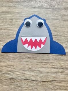 a paper cut out of a shark with big eyes