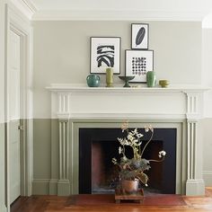 a living room with a fire place and pictures on the fireplace mantel above it