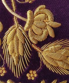 gold jewelry is displayed on a purple cloth