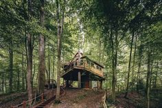 a cabin in the woods with stairs leading up to it's upper floor and second story