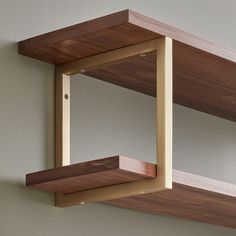 two wooden shelves on the wall, one is white and the other has brown wood