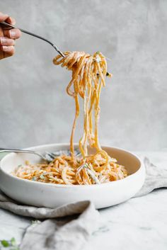 someone is holding a fork full of spaghetti and it's ready to be eaten