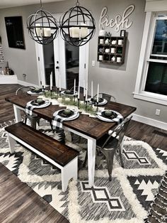 a dining room table with two benches in front of it and an area rug on the floor