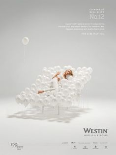 a woman laying on top of a pile of white balloons