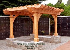 a wooden pergoline in the middle of a brick patio