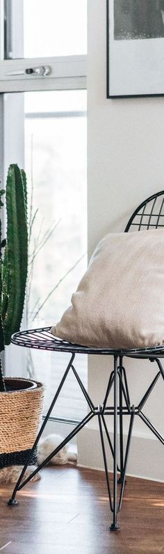 a bed sitting on top of a wooden floor next to a potted plant