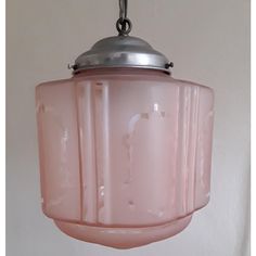 a pink glass light hanging from a ceiling