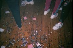 three people standing on the floor surrounded by confetti and playing cards