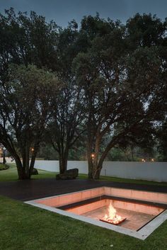 a fire pit surrounded by trees and grass