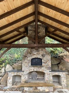 an outdoor fireplace in the middle of a covered area