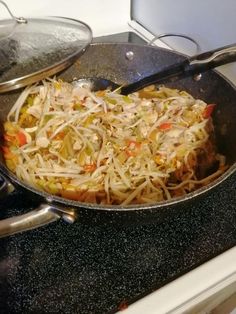 a pan filled with food sitting on top of a stove next to a frying pan