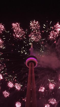 fireworks are lit up in the night sky above a tower with a clock on it