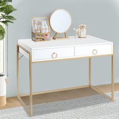 a white desk with two drawers and a mirror on it next to a potted plant