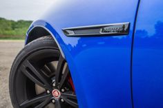 the front end of a blue car with black rims and red brake pads on it