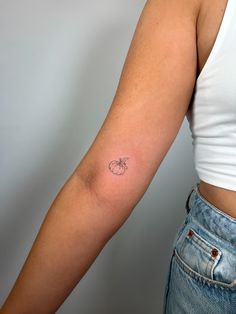 a woman's arm with a small tattoo on the left side of her arm