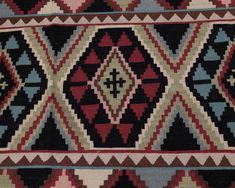 an old rug with many different colors and patterns on it's sides, including black, red, green, blue, beige