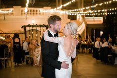 a bride and groom sharing their first dance at their wedding reception in front of an audience