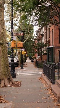 a street sign on the side of a tree lined sidewalk