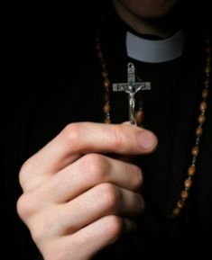 a person holding a cross in their hand and wearing a rosary on the other side