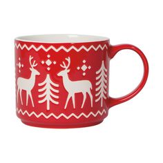 a red mug with white deers and trees on it