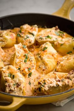 a skillet filled with potatoes covered in cheese