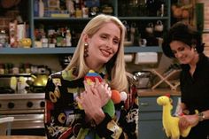 two women standing in a kitchen holding stuffed animals