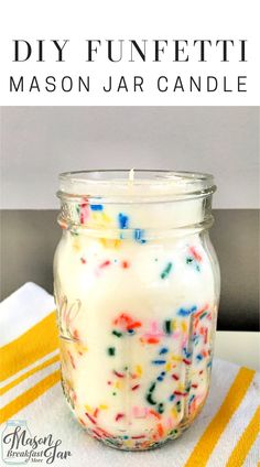 a glass jar filled with colorful sprinkles on top of a white towel