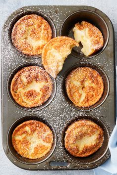 baked pastries in a muffin tin with powdered sugar on the top and bottom