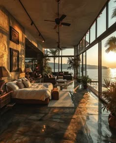 a bedroom with large windows overlooking the water and palm trees in front of an ocean view