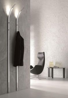 a chair and coat rack in a white room with marble walls, floor to ceiling windows