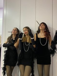 three women dressed in flappers and garters are standing next to each other