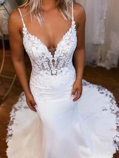 a woman in a white wedding dress posing for the camera with her hands on her hips