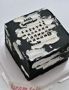 a black and white cake with writing on it