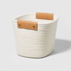 a large white basket with leather handles