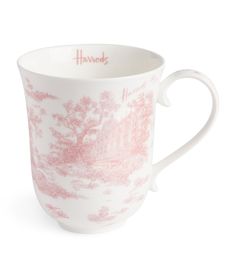 a pink and white coffee cup with trees on it