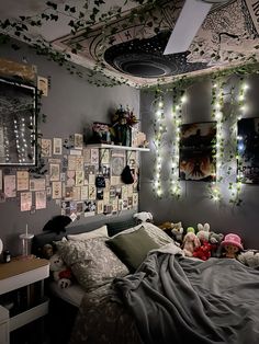 a bedroom with lights strung from the ceiling and stuffed animals on the bed