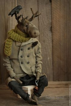 a stuffed animal sitting on top of a white chair next to a wooden wall with a bird perched on it's head