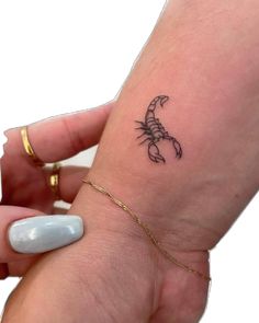 a small scorpion tattoo on the wrist