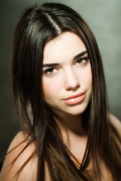 a woman with long brown hair posing for the camera