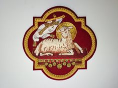 a red and gold plaque with an image of a ram on it's side