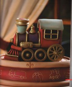 a close up of a cake made to look like a train on top of books